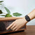 Digital retro-armbandsur med svart display på handleden, svart silikonband