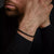 "Svart armband med små skivpärlor på handleden"