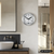 Runde silberne Wanduhr an der Wand, weißes Zifferblatt, schwarze Zeiger, Digitalanzeige 21