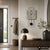 Wanduhr an der Wand mit Betonoptik-Design, schwarzen Zeigern, Ziffern und Pendel