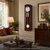 Wanduhr aus dunklem Holz mit rundem Zifferblatt und vertikalem Pendel