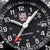 Sportklockans urtavla med LUMINOX-logotyp, vita siffror, lysande punkter och datumvisning