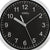 Nahaufnahme Wanduhr mit schwarzem Ziffernblatt, AMS-Schriftzug und Aluminiumrahmen